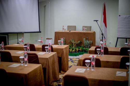 a conference room with tables with wine glasses on them at Infinity Hotel Jambi By Tritama Hospitality in Jambi