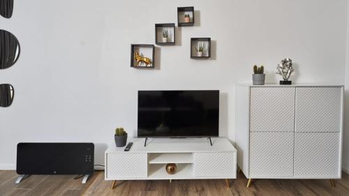 a living room with a tv and a white cabinet at Blissful Resort - Valea Doftanei in Teşila