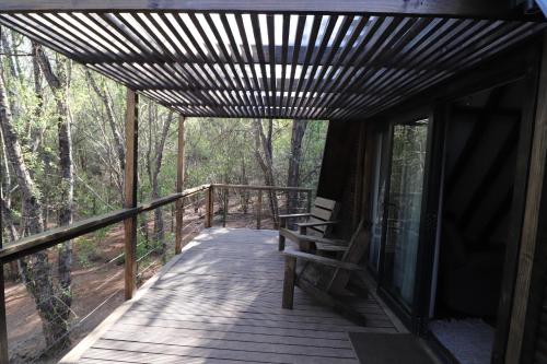 a wooden porch with a bench on a deck at Treehaven Retreat in Hogsback