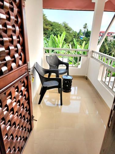 a balcony with two chairs and a window at Ocean Front Villa, Ngeme in Limbe