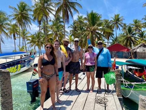 a group of people standing on a dock next to a boat at Isla aguja San Blas in Panama City