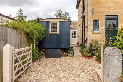 a tiny house in a garden with a fence at Shepherd's Hut, Bath in Bath