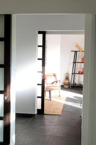 a hallway with a chair and a room with a door at T2 Moderne avec piscine Oasis de nature et Sérénité in Richemont