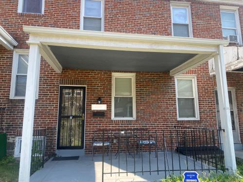 a brick building with a door with chairs in it at Home Away From Home in Baltimore