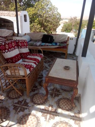 a porch with a couch and a coffee table at Nubian Life Nile View in Aswan