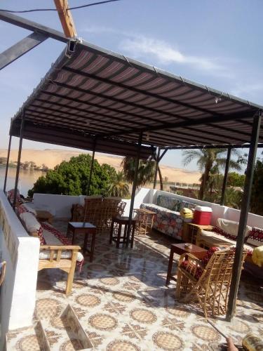 a patio with tables and chairs under a canopy at Nubian Life Nile View in Aswan