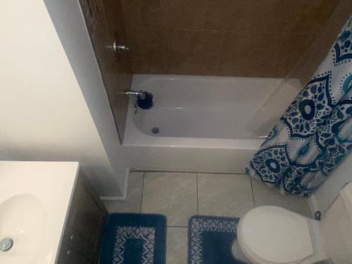 een kleine badkamer met een bad en een toilet bij Home Away From Home in Baltimore