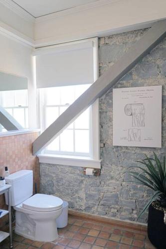 a bathroom with a toilet and a window at Perfect Santa Rosa Escape at Historic Stonehouse! in Santa Rosa