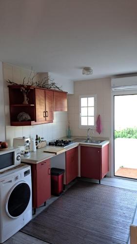 a kitchen with red cabinets and a white stove top oven at Arenal den Castell Castellsol in Arenal d'en Castell