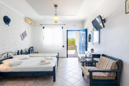 a bedroom with two beds and a tv and a chair at Sirines in Vlachata