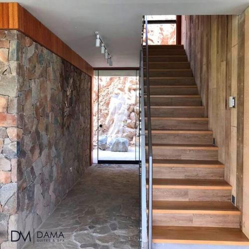 a staircase in a house with a stone wall at Casa Dama in Cieneguilla