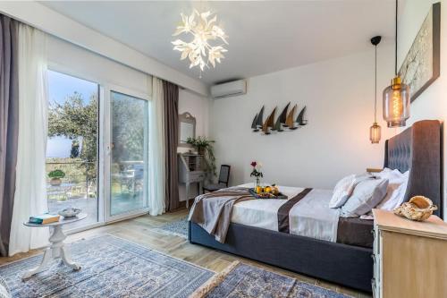 ein Schlafzimmer mit einem Bett und einem großen Fenster in der Unterkunft Skopelos Blue Heaven Pool Villa in olive grove in Skopelos