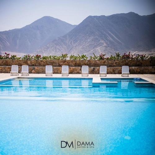 a swimming pool with chairs and mountains in the background at Casa Dama in Cieneguilla