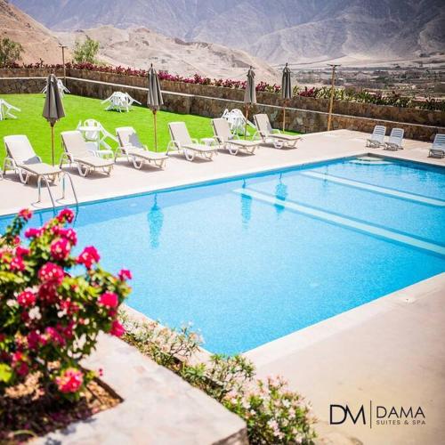 a swimming pool with chairs and umbrellas at Casa Dama in Cieneguilla