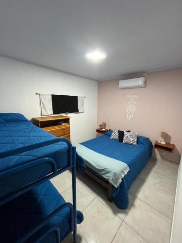 a bedroom with two beds and a flat screen tv at casa quinta caballito blanco in Chascomús