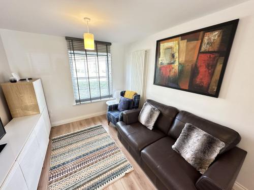 a living room with a couch and a chair at Casa Crusoe - Part of the The Bay Filey Holiday Village with pool, gym and direct beach access, pub, restaurant, tennis and meadows walks in Reighton