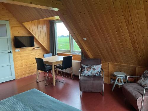 a room with a bed and a table and chairs at B&B en Vakantiehuisje Ursula in Workum