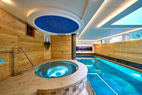 a swimming pool with a blue tub in a room at Hotel Cristina in Pinzolo