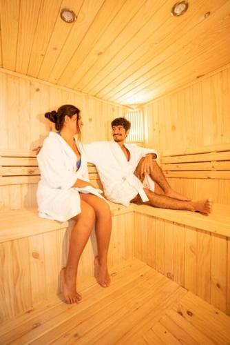 a man and a woman sitting in a sauna at Casa Dama in Cieneguilla