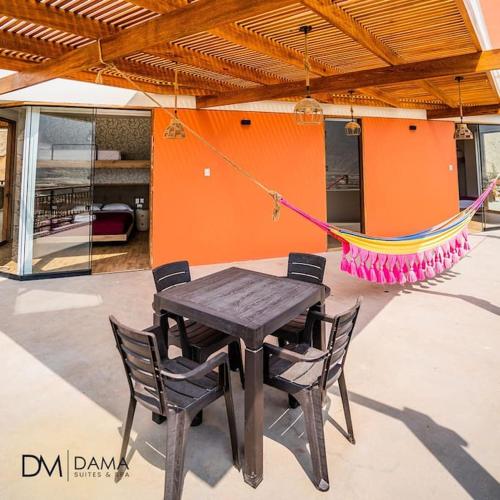 a wooden table with chairs and a hammock in a house at Casa Dama in Cieneguilla