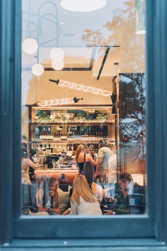 a group of people sitting at a bar through a window at The Postmark Hotel in Newmarket