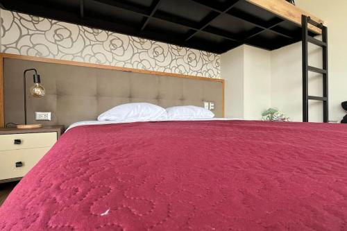 a large red bed with two pillows on it at Casa Dama in Cieneguilla