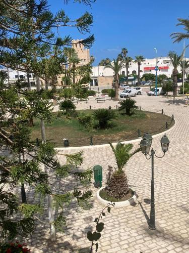 a park with a palm tree and a street light at Sousse Marina Kantaoui l'expérience côtière in Port El Kantaoui