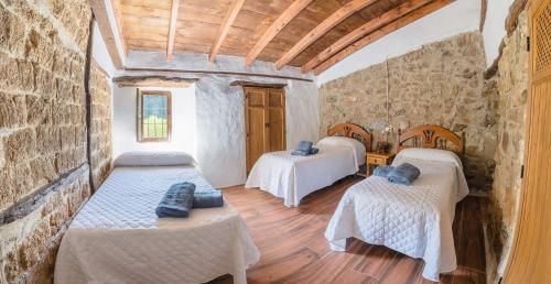 Zimmer mit 2 Betten in einem Steingebäude in der Unterkunft Cortijo Rural Las Nogueras in Cortijada Los Chorreros