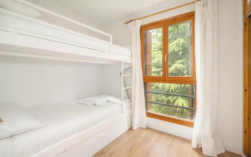 a bedroom with a bed and a window at La gran plaza de candanchu in Candanchú