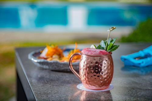 a drink in a cup on a table with a plate of food at Presidente InterContinental Puebla by IHG in Puebla