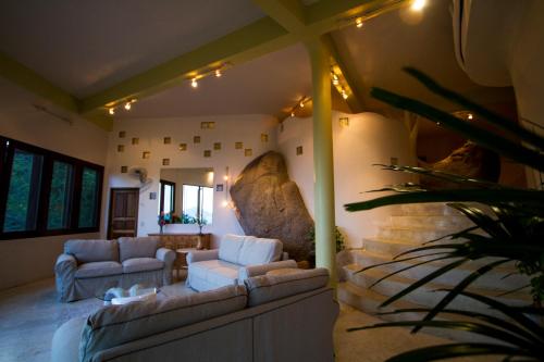 a living room with two couches and a stone wall at Monkey Flower Villas in Koh Tao