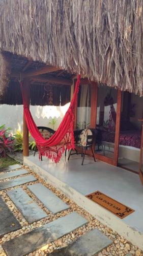 a hammock in the middle of a resort room at 4 Elementos Guest House in Arraial d'Ajuda