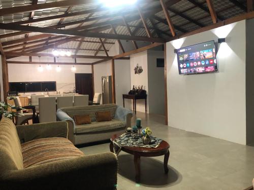 a living room with couches and a tv on a wall at Entre Brisas y Árboles in Puyo