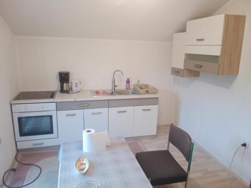 een kleine keuken met een tafel en een gootsteen bij Vila Anđelija in Velika Kladuša