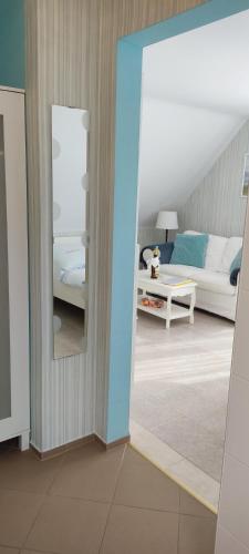 a living room with a couch and a mirror at Ferienwohnung Schmetterling II in Grossenbrode