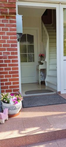 a front door of a house with two pots of flowers at Ferienwohnung Schmetterling II in Grossenbrode