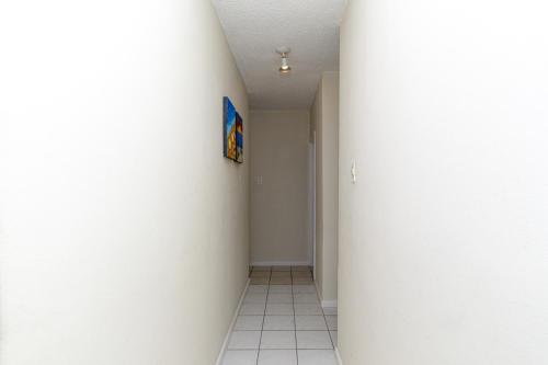 a hallway with a white wall and a pillar at Modern Seaview Apartment in Summerstrand