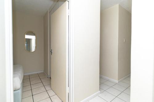 a bathroom with a mirror and a white closet at Modern Seaview Apartment in Summerstrand