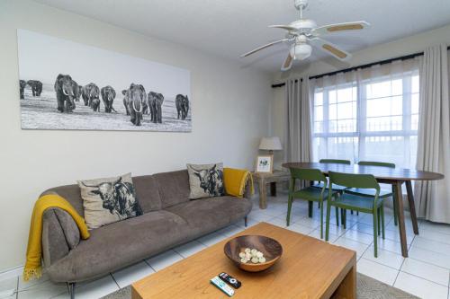 a living room with a couch and a table at Modern Seaview Apartment in Summerstrand