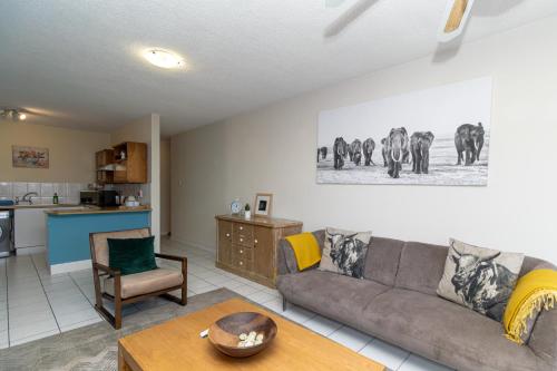 a living room with a couch and a kitchen at Modern Seaview Apartment in Summerstrand