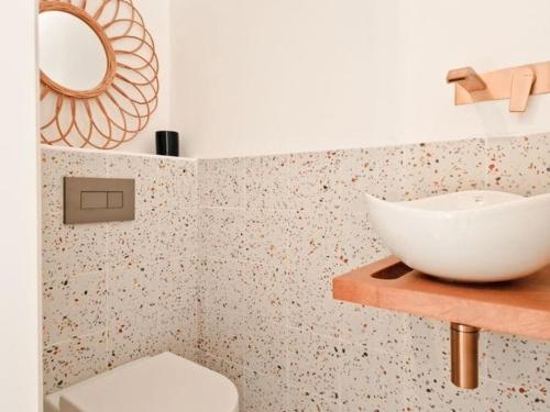 a bathroom with a white sink and a toilet at Casa das Mélias in Vilamoura