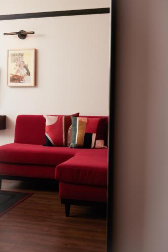 a red couch sitting in a living room at The Postmark Hotel in Newmarket