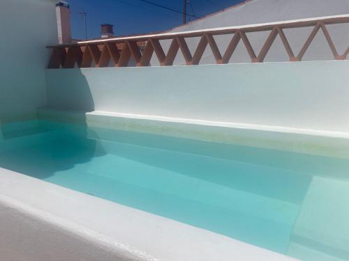 a pool of blue water next to a building at Casa Vó Briata in Mértola