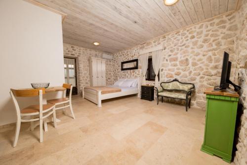 a bedroom with a bed and a table and chairs at Old House Leković in Godinje