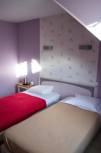 deux lits côte à côte dans une pièce dans l'établissement Le relais du chapeau rouge, à Vibraye