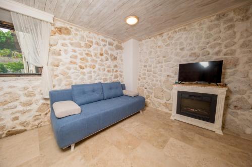 a living room with a blue couch and a fireplace at Old House Leković in Godinje