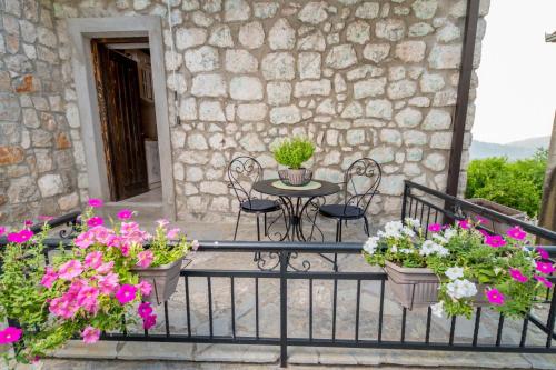 a balcony with a table and chairs and flowers at Old House Leković in Godinje