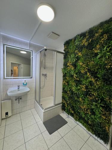 a bathroom with a green wall with a shower and a sink at Apartment in zentraler Lage No 3 in Rostock