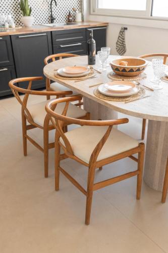 une table à manger avec quatre chaises et une table blanche dans l'établissement Serenity Escape Marseille - SEA VIEW & SUNSET, à Marseille