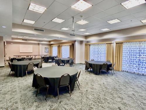 a conference room with tables and chairs and a screen at Holiday Inn Express & Suites Lexington by IHG in Lexington
